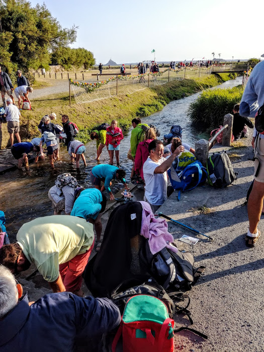 Fin du pèlerinage des grèves près du pont de Genêts. Chacun plonge ses pierre dans le Lerre pour se laver les pieds de la vase et du sable de la baie du Mont-Saint-Michel (Photo FC)