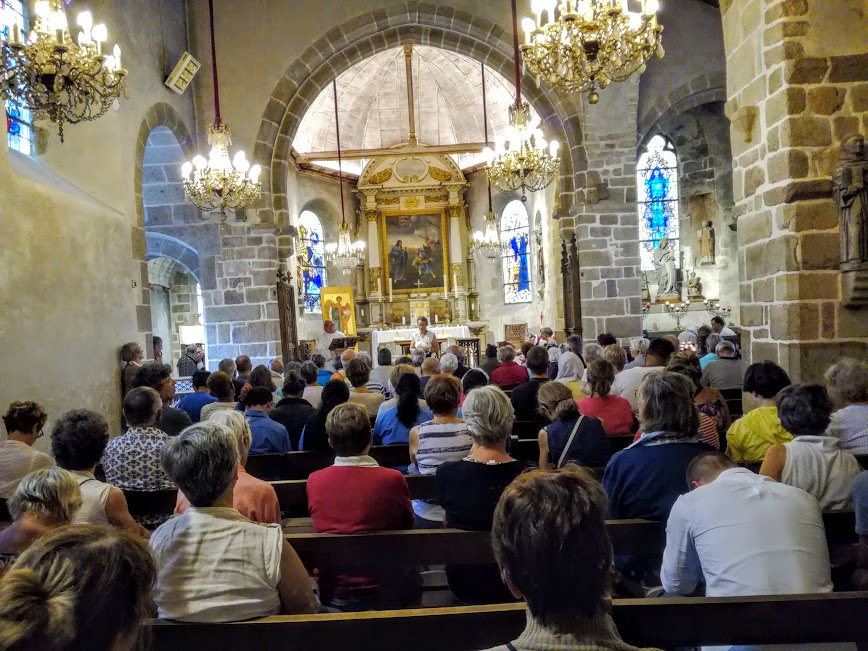 Cette petite église paroissiale Saint-Pierre dont le Père André Fournier est le recteur, impossible de la manquer car se situant sur l’unique ruelle pavée qui monte vers l’abbaye. Sa construction contre le flanc est du rocher au cœur du village date du XIe siècle mais elle a été fortement remaniée aux XVe et XVIe siècles. Sanctuaire de saint Michel, elle abrite une statue d'argent le représentant. En tant que centre du pèlerinage, elle a conservé de nombreux ex-voto sur ses murs (Photo FC)