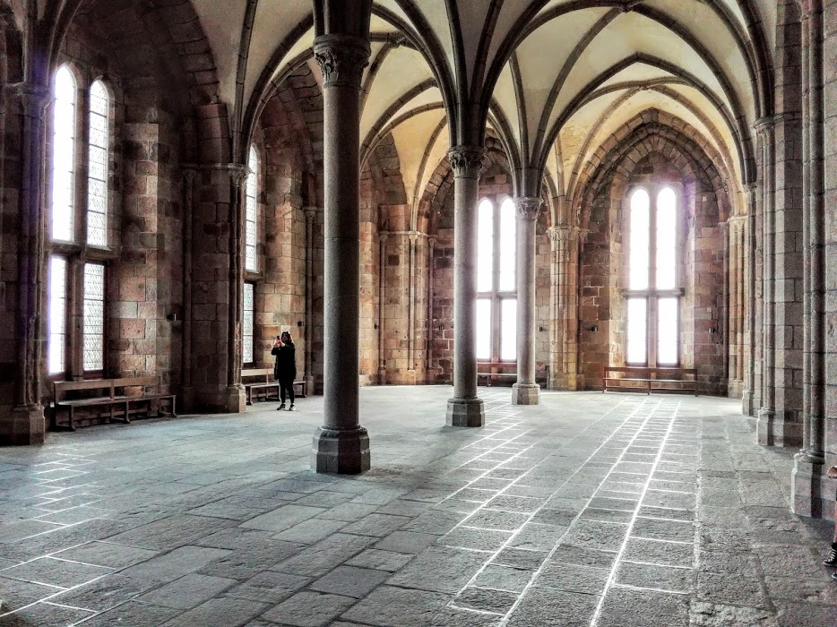 Abbaye du Mont-Saint-Michel : la salle des Hôtes. Elle est adjacente à la salle des Chevaliers et se caractérise par des colonnes très fines et des fenêtre très hautes. Le mur ouest est entièrement occupé par deux immenses cheminées. C'est sans doute là qui furent accueillis les rois qui y vinrent, de Saint Louis (Louis IX) à Charles IX (Photo FC)