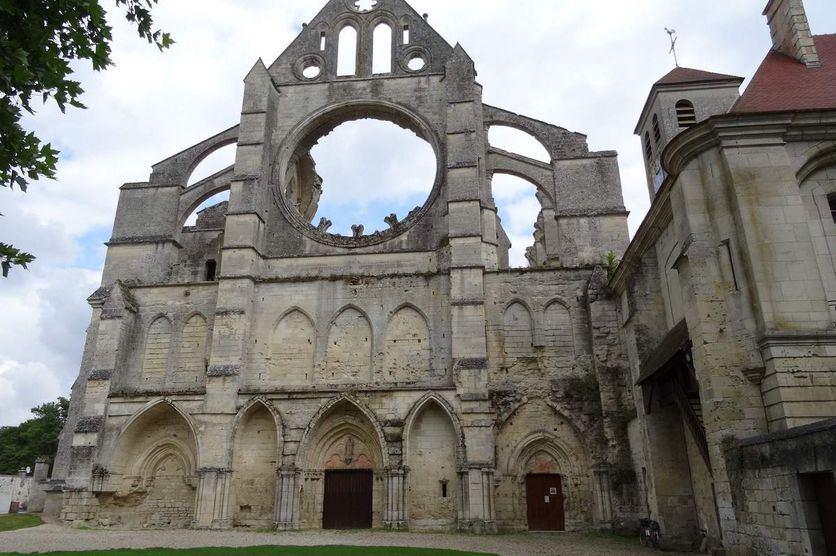 Façade principale de l'abbatiale cistercienne de Longpont, épaulée par de puissants contreforts. A droite l'entrée et le clocher de l'église paroissiale qui occupe modestement quatre travée dans la partie de l'ancien cellier.