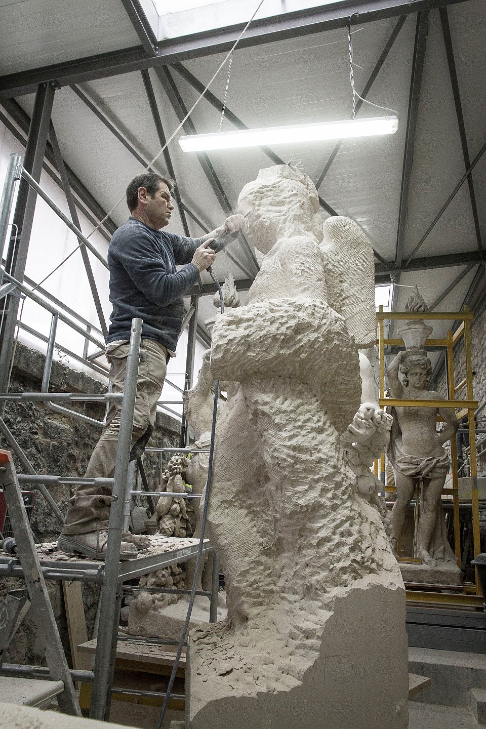 Taille directe de l'un des sculpteurs de l'une des 4 entreprises à partir d'un bloc de pierre de Saint Leu (4 tonnes et d'une hauteur de 3,50 m) Photo DR