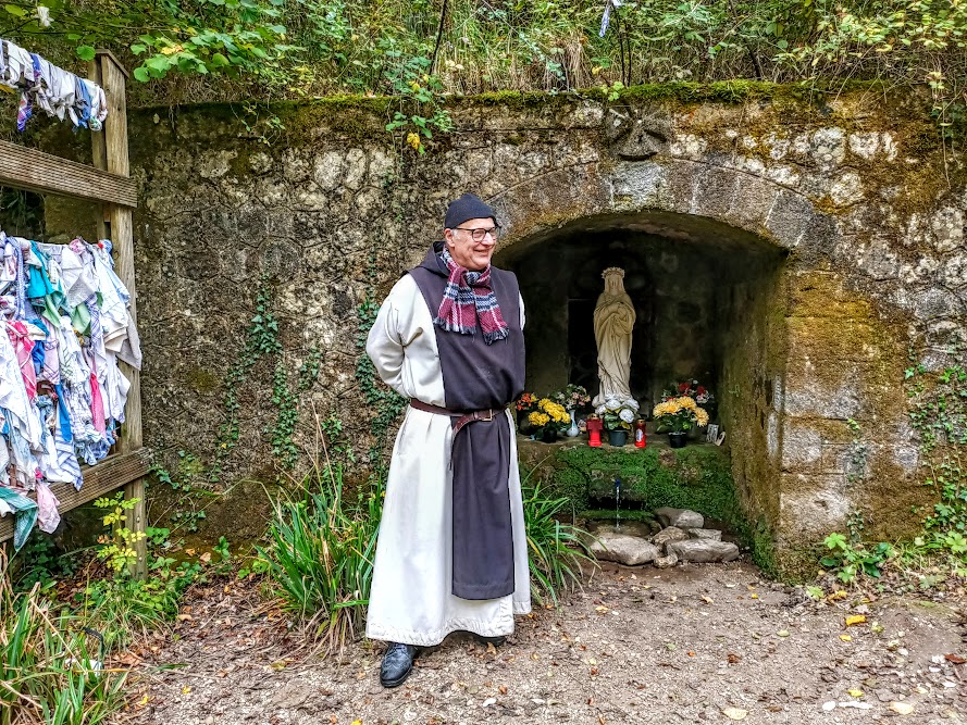 Frère Marie-Pâques, devant la Fontaine des yeux située un peu en aval de Notre Dame de Nize. C’est un lieu de pèlerinage qui attire croyant et non croyant venus découvrir cette source et/ou chercher soulagement (ou guérison !), tout particulièrement pour les yeux (Photo FC)